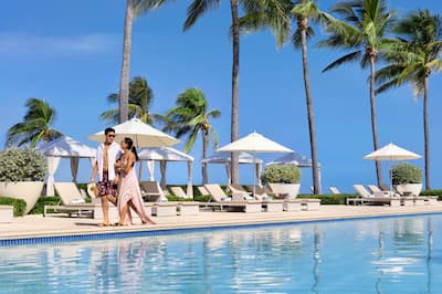 Couple walking by pool at Hilton Rose Hall, an all-inclusive resort. 