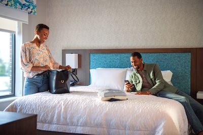 A smiling couple lounging on a Hampton bed
