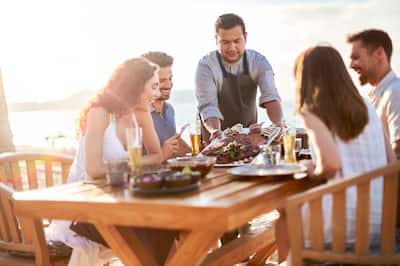  A group of four people outside having a meal served to them