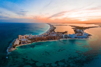 Beach with crystal waters and buildings.