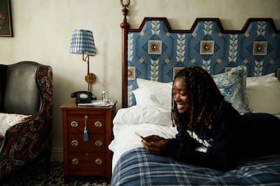Woman smiling as she relaxes on bed looking at phone