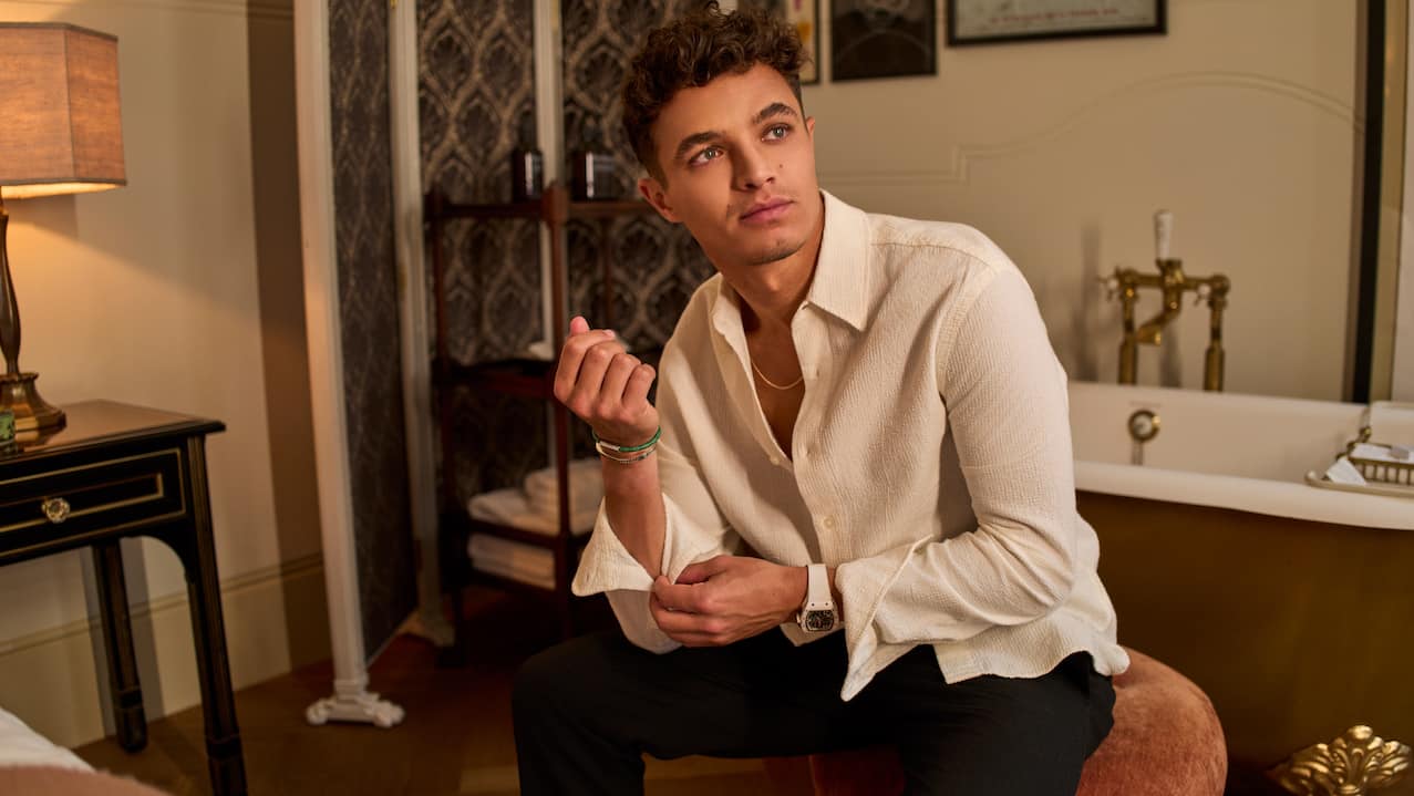 Lando Norris in guest room buttoning up shirt