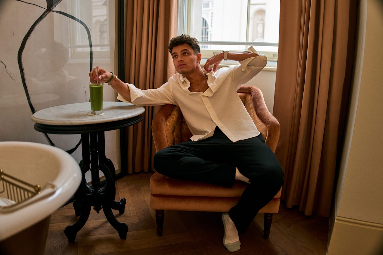 Lando Norris relaxing on chair with green drink