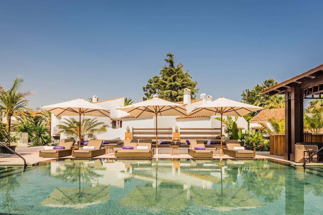 A pool with lounge chairs and umbrellas