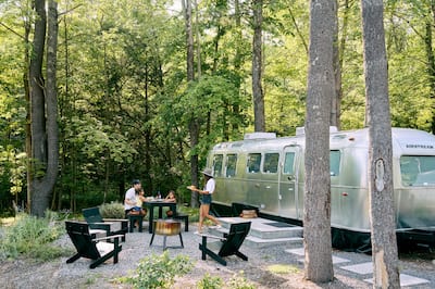 Exterior of static home with table, chairs and family