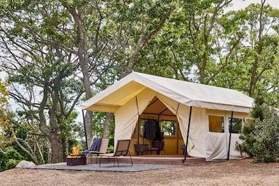 Luxury tent with outdoor seating and fire burning