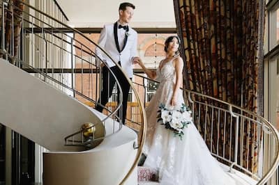 bride and groom looking out window on a spiral staircase