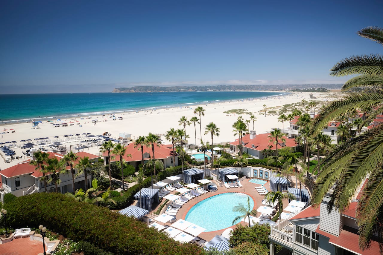 Overhead view of pool with loungers, and beach in background