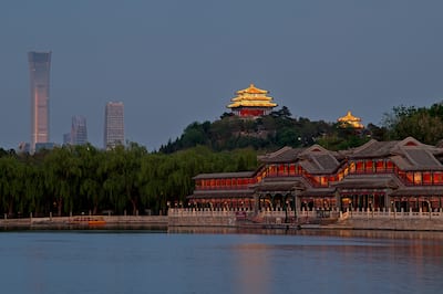View of building in Beijing with skyscrapers in the background and water in the foreground