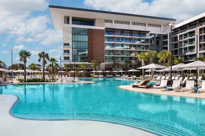 outdoor resort pool, palm trees, lounge chairs, hotel exterior 