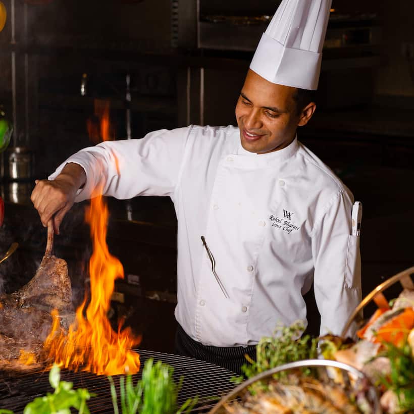 chef flame grilling steak