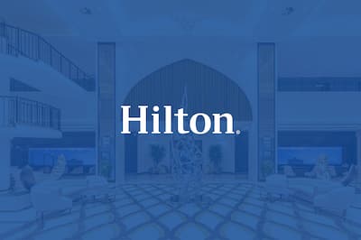 Hotel lobby with a blue overlay and Hilton Hotels and Resorts white logo displayed