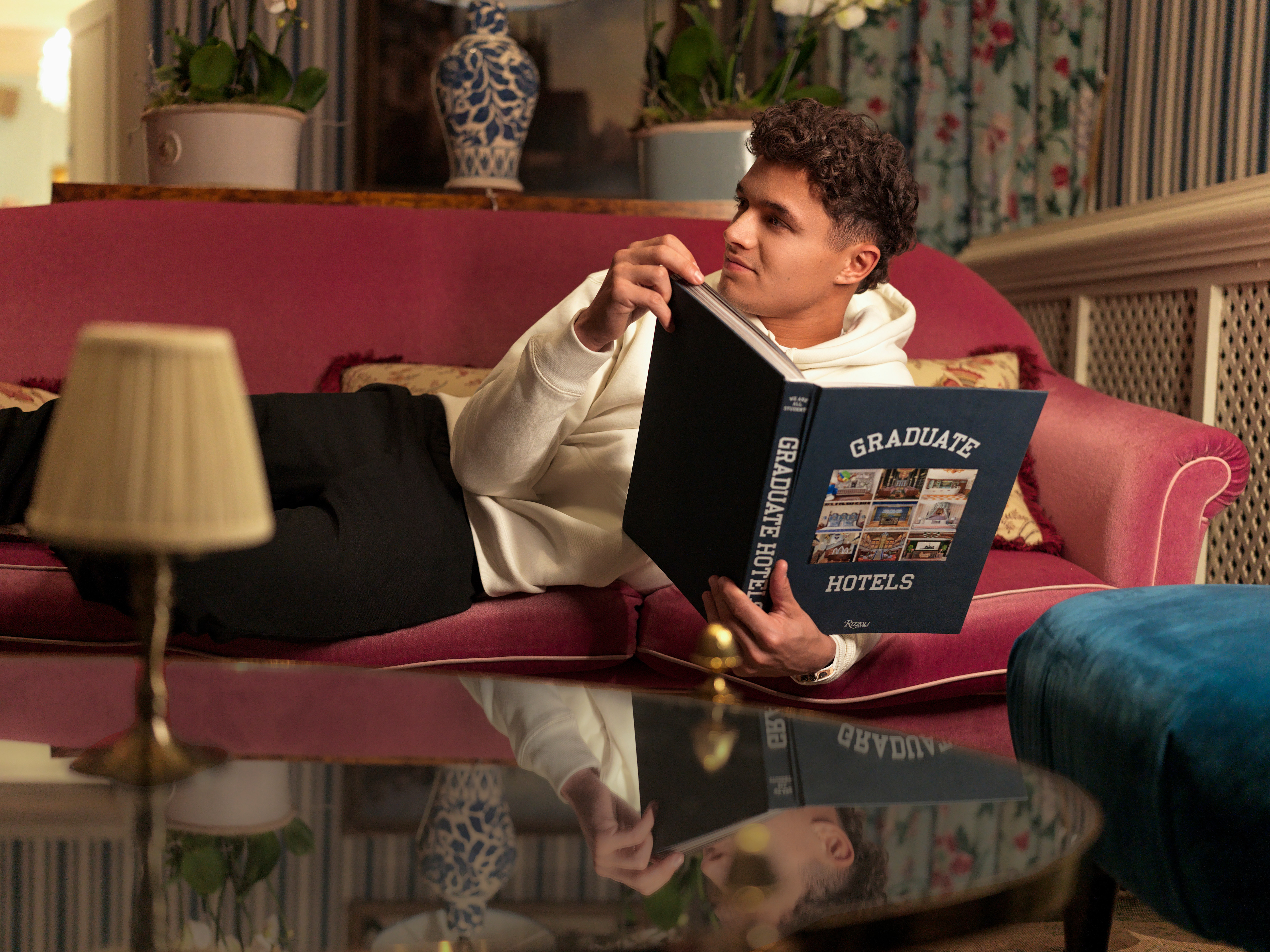 Lando Norris relaxes with book at Graduate Hotel by Hilton