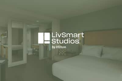 LivSmart Studios by Hilton guest room with LivSmart logo overlay