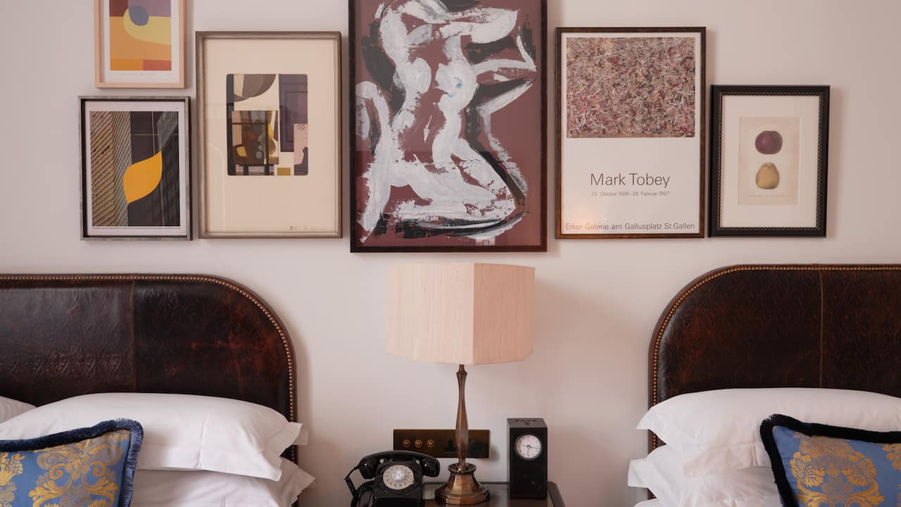 Two beds in room with lamp and telephone