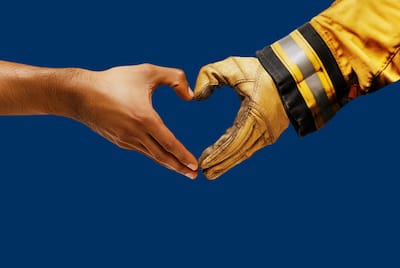 Hilton LA Wildfire Person and a Firefighter make a heart with their hands