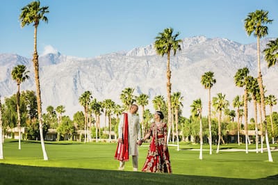 Wedding couple standing in garden in front of trees and mountains
