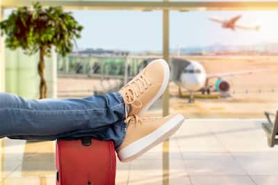 A pair of shoes relaxed on a suitcase at the airport