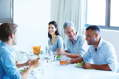 Three men and a woman enjoying lunch together