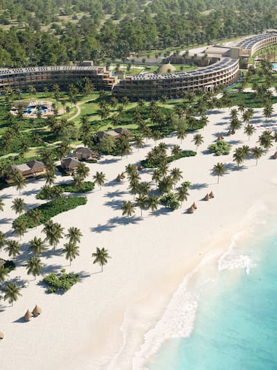 Aerial shot of resort with beach, trees and buildings